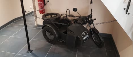 Una motocicleta con sidecar estacionada en el interior, atada a una pared.