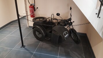 Una motocicleta con sidecar estacionada en el interior, atada a una pared.