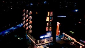 A multi-story hotel with a prominent 'HOTEL' sign, multiple balconies, and a parking area visible in the foreground. - Hotel 88 Bekasi By WH (Bekasi)