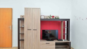 Mueble multimedia compacto con televisor, repisas y un gabinete.