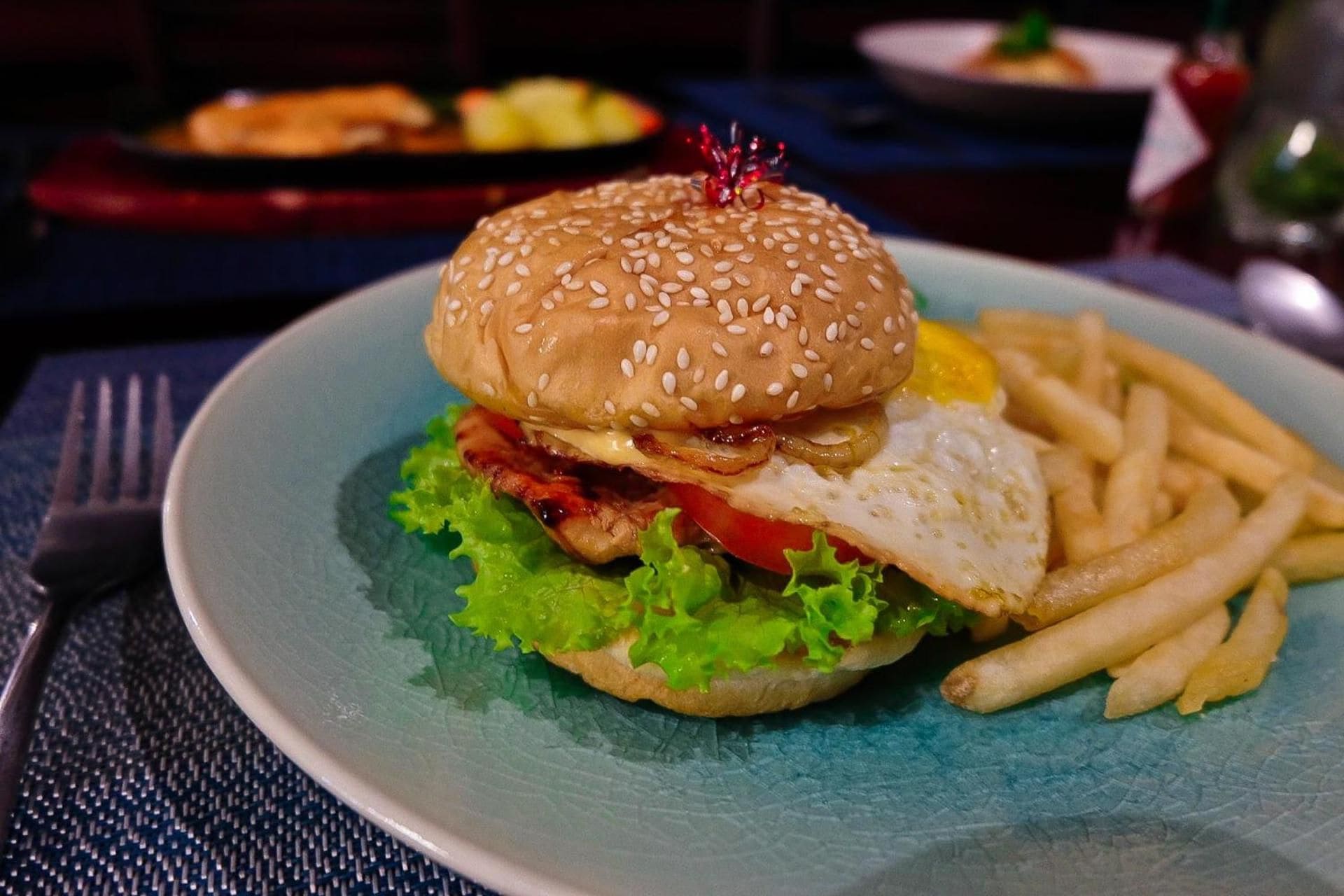 A plate with a burger, fries, and a side salad.