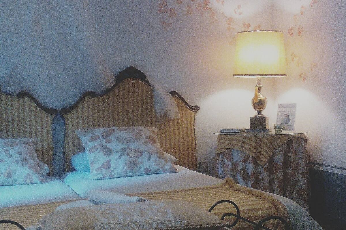 Une chambre avec un lit, une table de chevet et une lampe.
