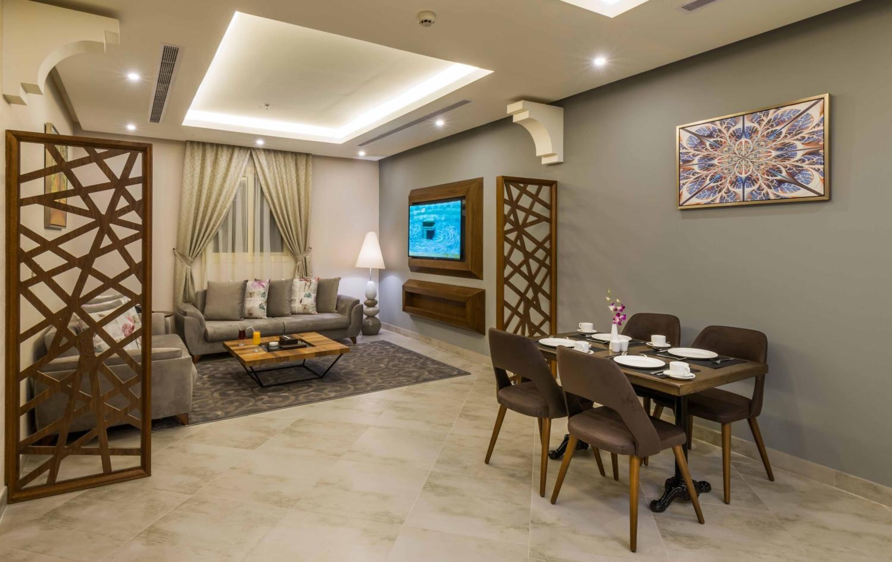 A modern living room with a sofa, coffee table, and dining area with chairs and a table set for a meal.