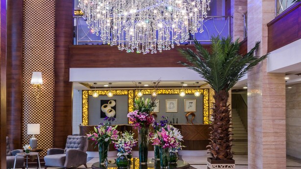 A lobby with a grand chandelier, a reception desk, and a seating area. - Boudl Quraish (Jeddah)