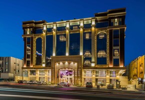 A multi-story hotel with a grand entrance, large windows, and a well-lit facade.