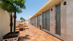 A corridor with a tiled floor, potted plants, and seating areas. - Boudl Quraish (Jeddah)