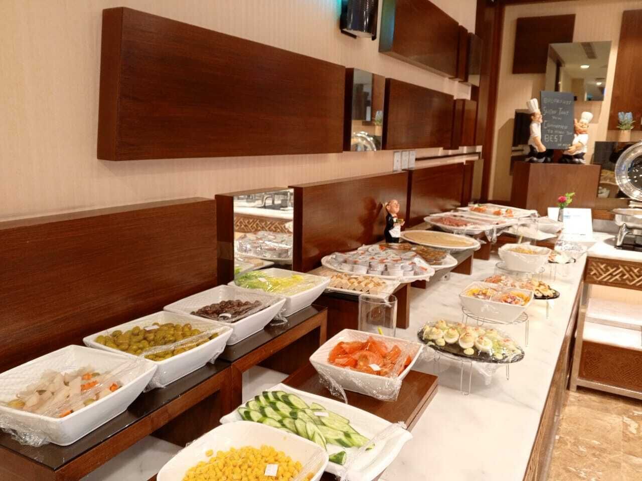 A buffet with various food items including fruits, vegetables, and prepared dishes.