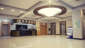 A hotel lobby with a reception desk, a large chandelier, and a clean, polished floor. - Uljin Grand Hotel (Uljin)