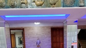 Un hall con un conjunto de sofás, una mesa de centro y una estatua.