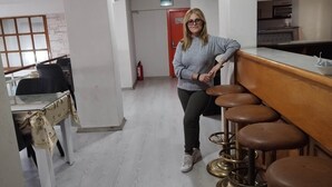 Un pasillo con una zona de bar que incluye taburetes, una mesa con sillas y un extintor.