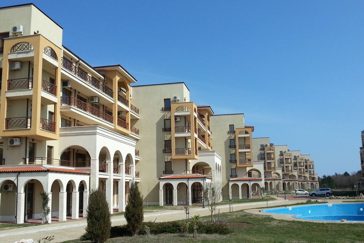 A row of multi-story hotel buildings with balconies and arched windows.
