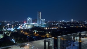 A nighttime cityscape with illuminated buildings and a clear view of the urban layout.
