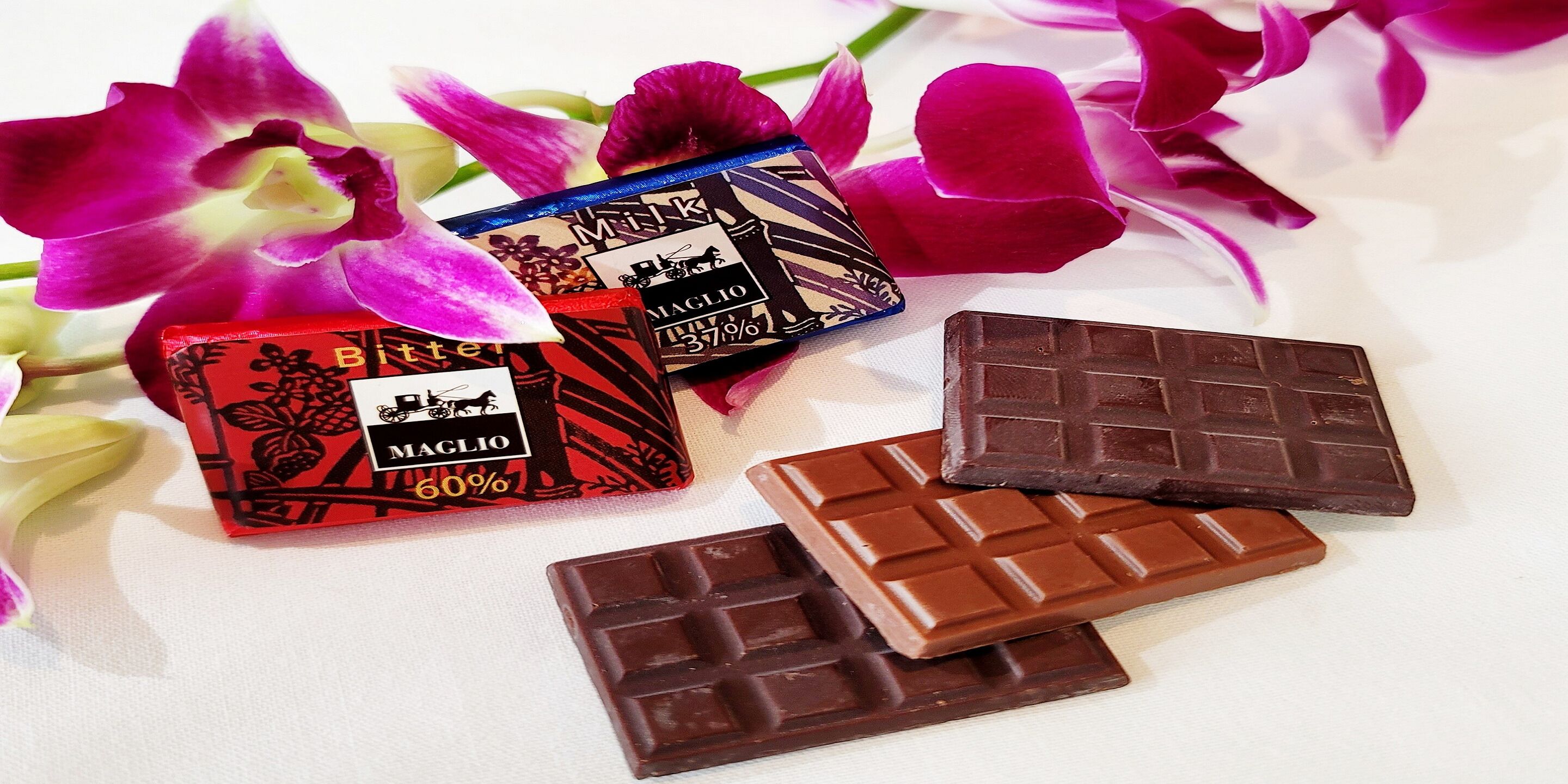 Tres barras de chocolate y dos cajas de chocolate con flores.