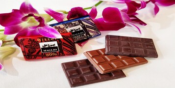 Tres barras de chocolate y dos cajas de chocolate con flores.