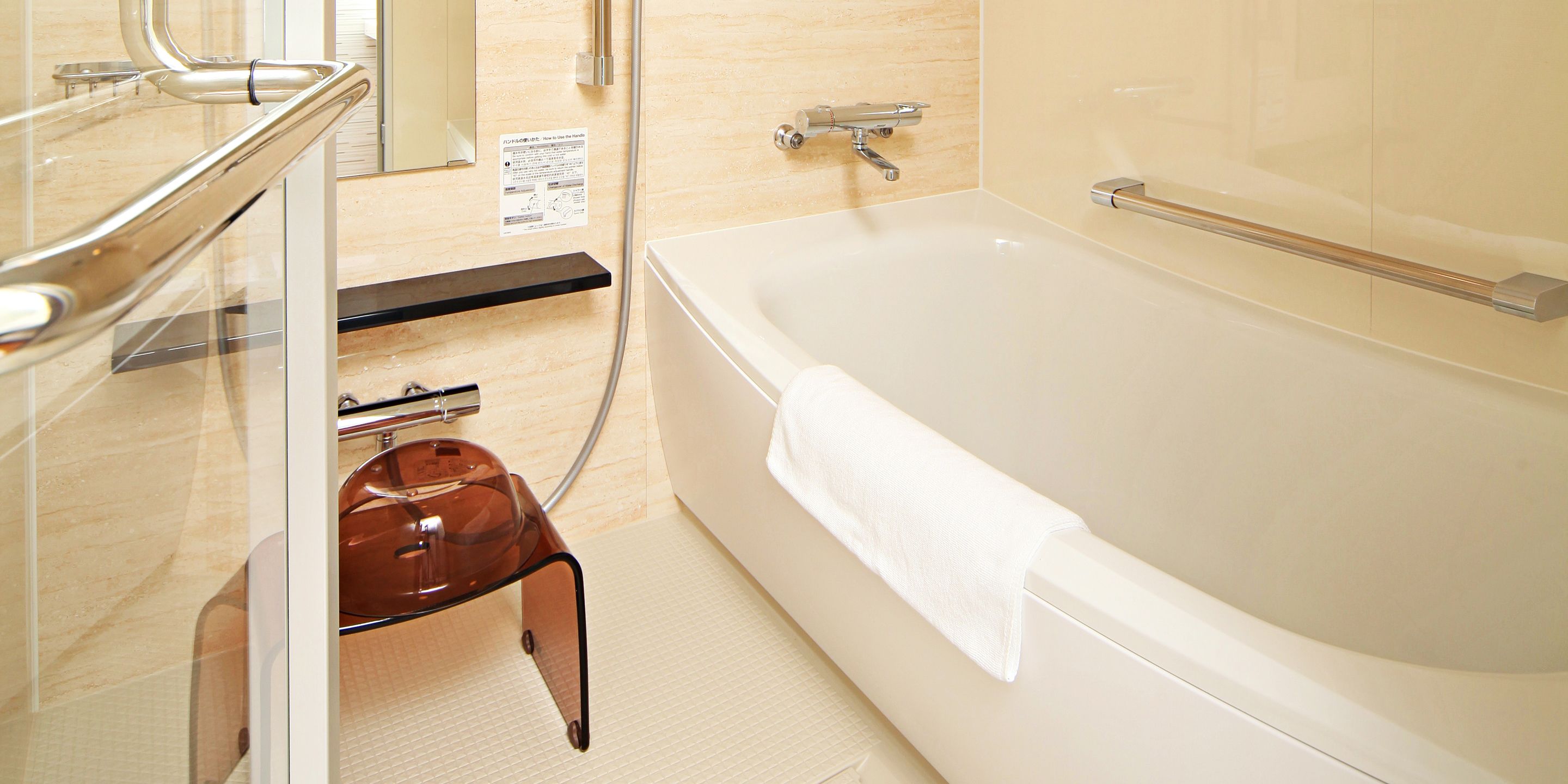 A modern bathroom with a glass shower enclosure, a white bathtub, and a wooden bench.