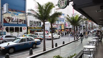 A busy street with various shops and a visible Starbucks Coffee sign.