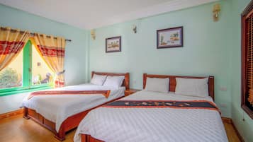 Une chambre avec deux lits, une fenêtre avec des rideaux et deux tableaux accrochés au mur.