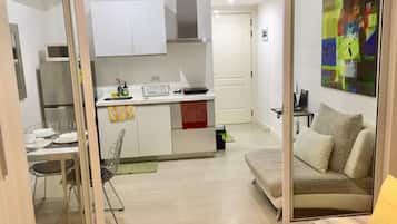 A compact living space with a kitchenette, a dining area, and a sofa.