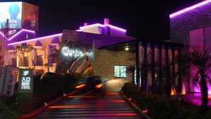 A hotel entrance with a modern design, featuring a prominent archway and a sign indicating an entry point. - Romantic Code Motel (Tainan)