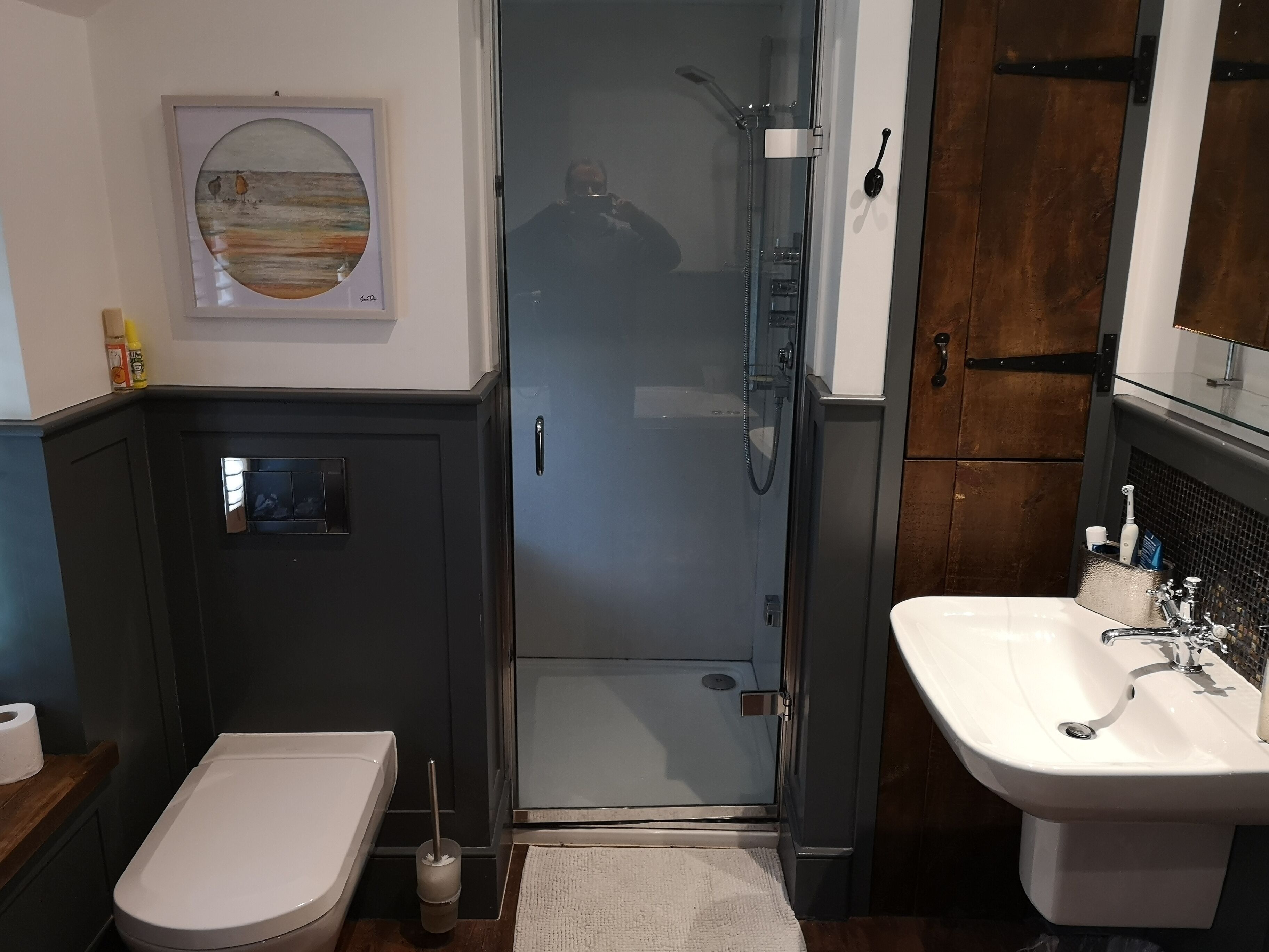 A bathroom with a toilet, sink, and shower.