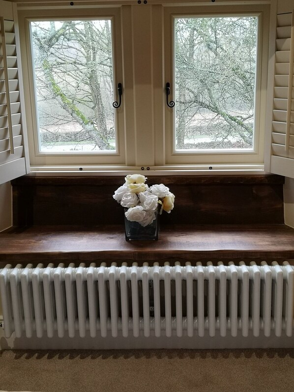 A room with a windowed bench area, a radiator below, and a view of trees outside. - Robin Hood Farm B&B (Bakewell)