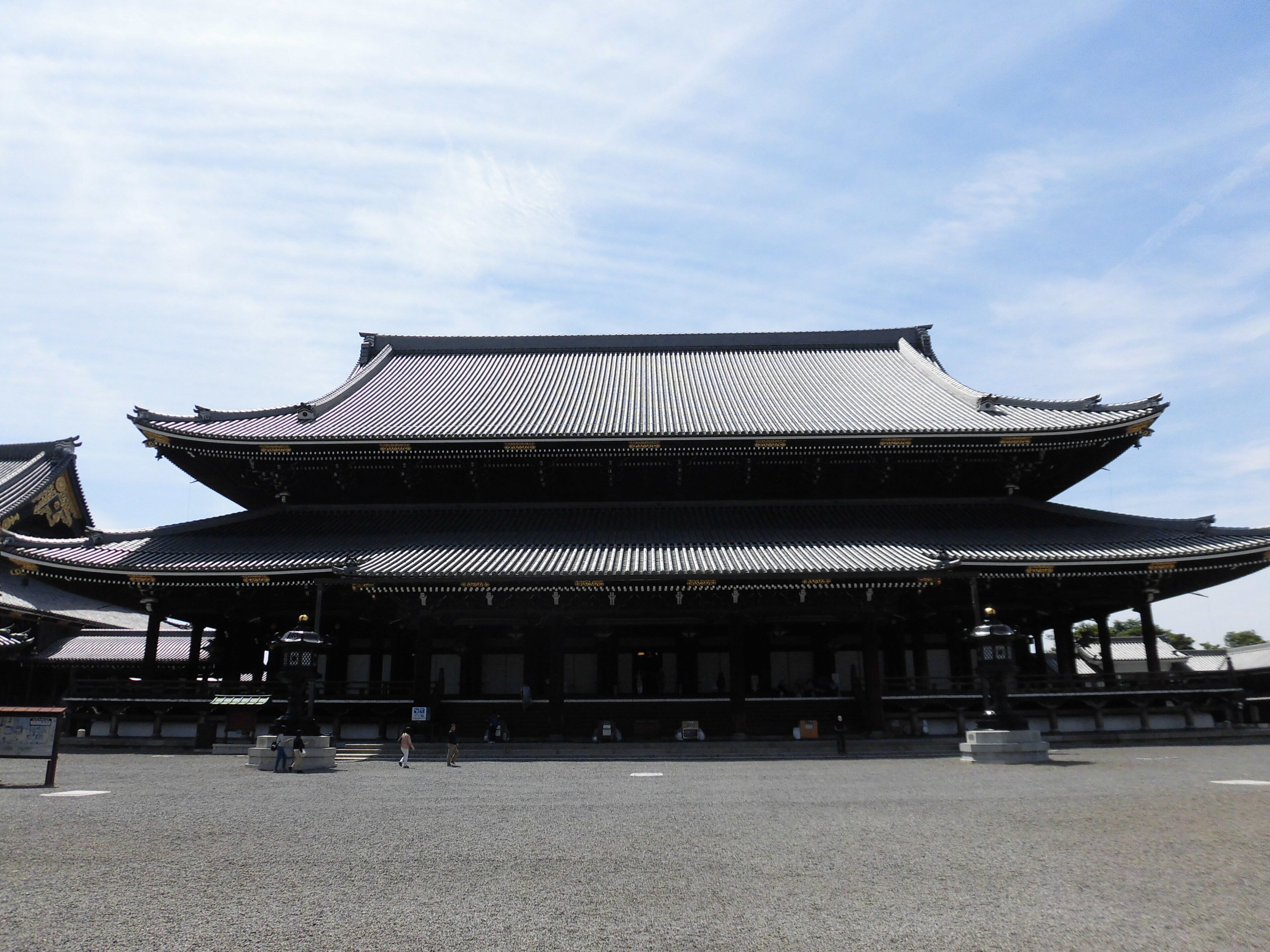 Um edifício japonês tradicional com telhado em vários níveis e um pátio de cascalho.