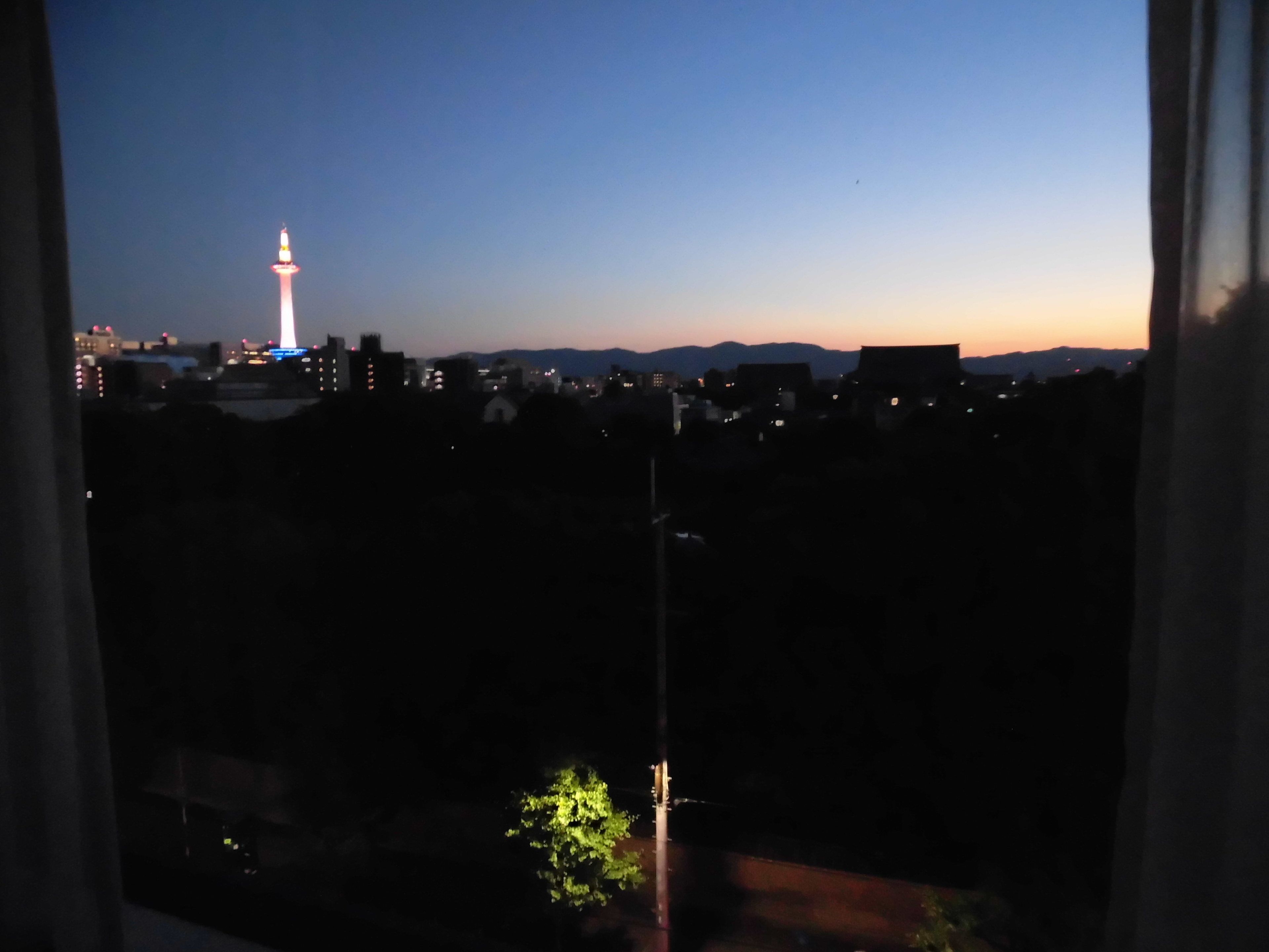 A nighttime cityscape with a prominent tower lit up in the distance.