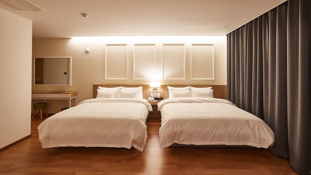 A hotel room with two beds, a desk, and a large window with curtains. - Pyeongchang Hotel The Maru (Pyeongchang)