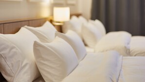 A hotel room with a neatly made bed, a bedside lamp, and a curtain. - Pyeongchang Hotel The Maru (Pyeongchang)