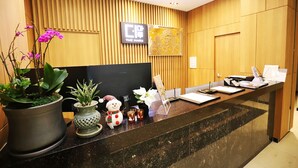 A modern reception desk with a Samsung monitor, a wooden panel wall, a world map, and a sign reading "THE MARU". - Pyeongchang Hotel The Maru (Pyeongchang)