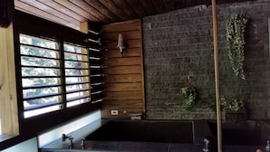 A modern interior with a stone wall, wooden slats, and a view through a large window. - 51 Spring (New Taipei City)