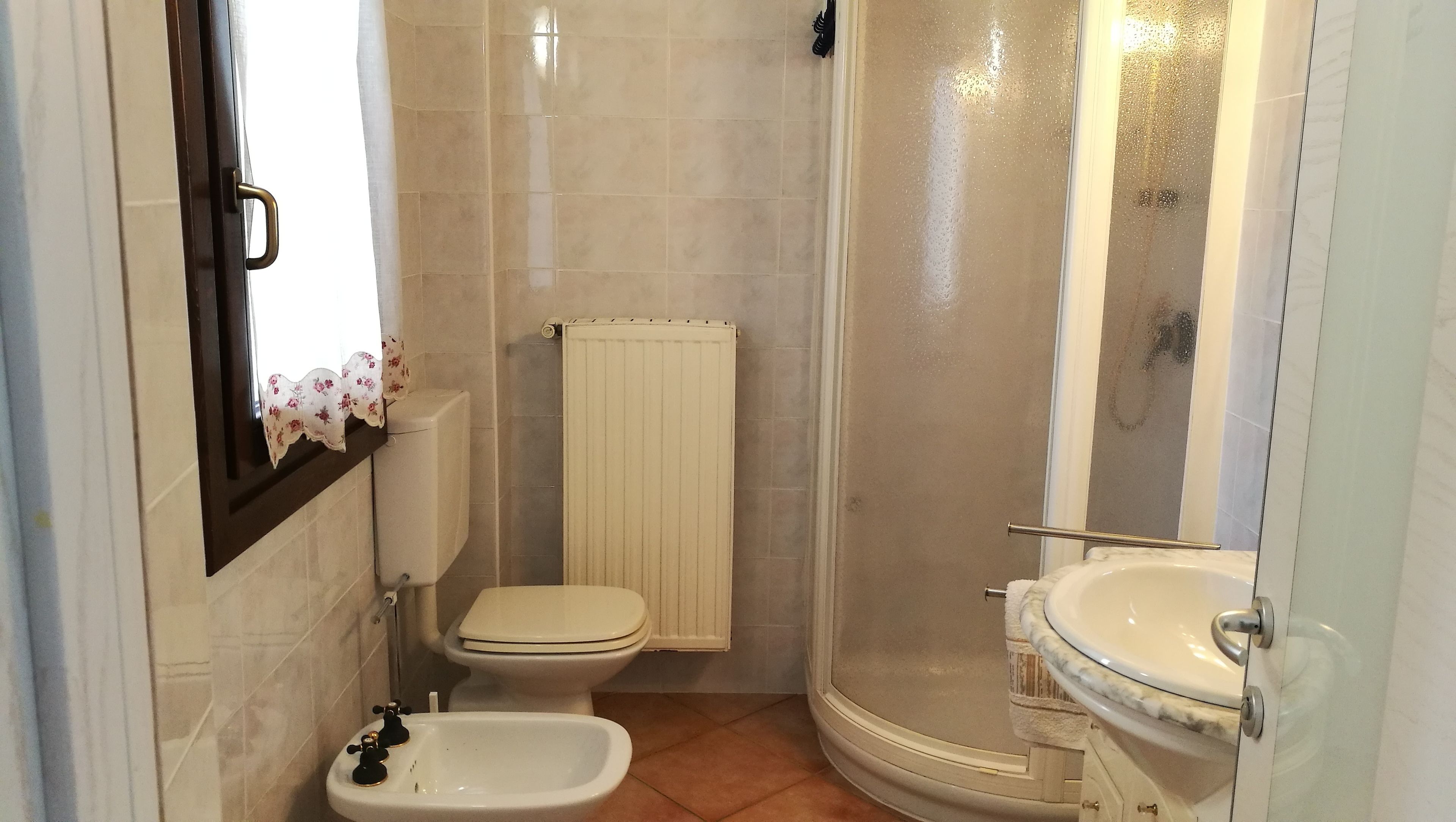 A small bathroom with a toilet, bidet, and sink.