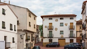 A narrow street with buildings featuring balconies, a stone wall, and a wooden gate. - Hotel La Gerencia (Checa)