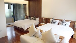 A hotel room with two beds, a sofa, and a glass door leading to a balcony. - Peace Area Hot Spring Hotel (Jiaoxi)