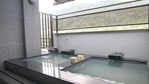 A modern spa with a glass-enclosed hot tub, wooden steps, and a view of a forested hillside. - Peace Area Hot Spring Hotel (Jiaoxi)