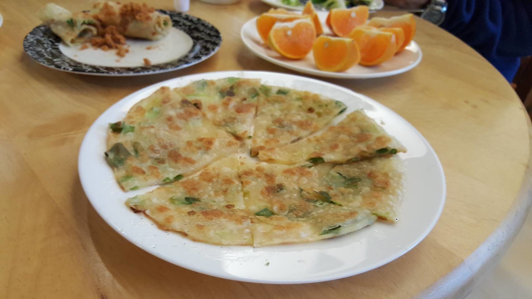 A plate of food with a slice of pie and a plate of oranges.