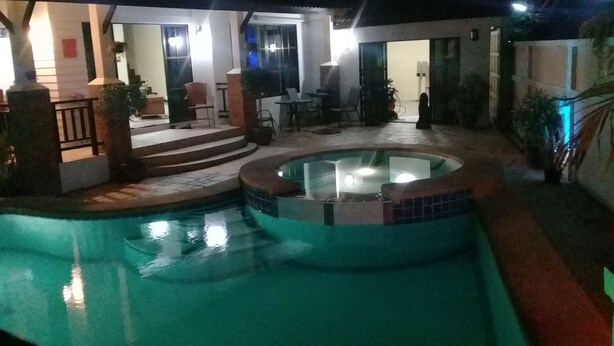 A swimming pool with a hot tub, surrounded by a patio area with steps leading to a covered seating area. - 4 Bedroom House & Private Pool Pattaya (Pattaya)