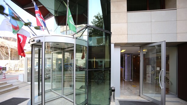 A modern building entrance with a revolving door and glass doors. - Grand Nora Hotel (Ankara)