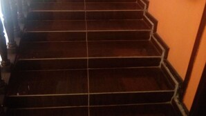 Un escalier avec une main courante sur le côté droit, menant à l’étage supérieur.