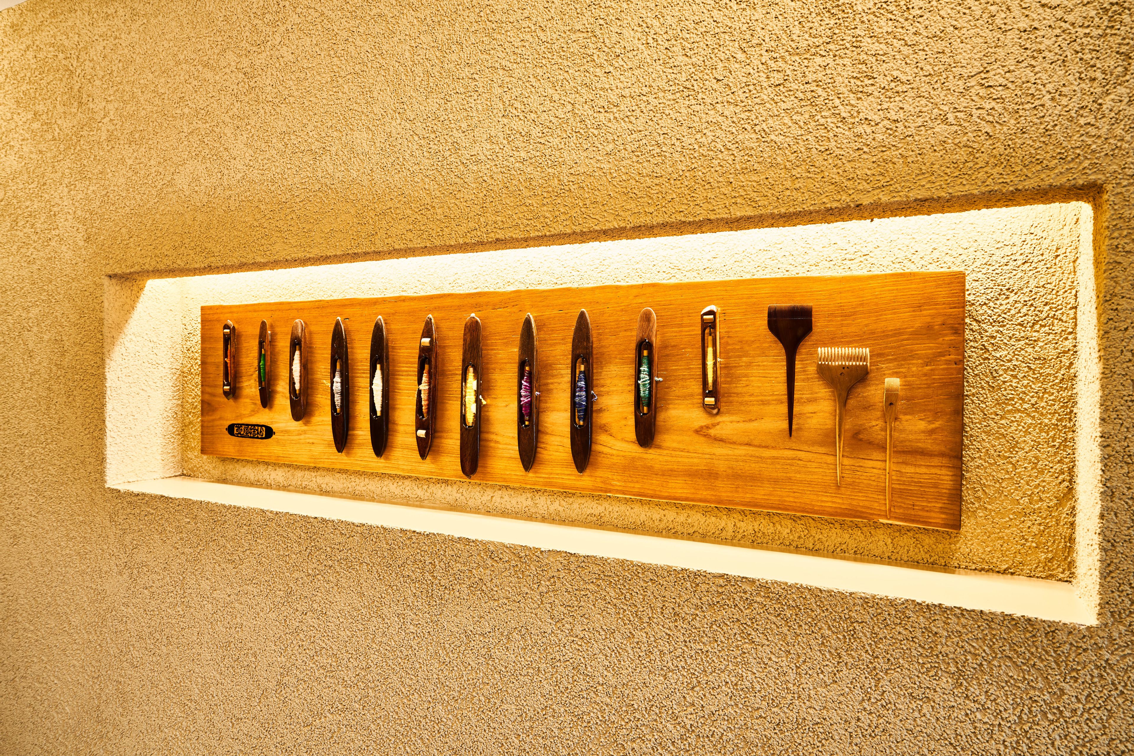 A wooden display case with various knives mounted on it.