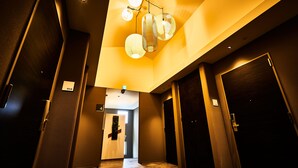 A hotel corridor with a modern design, featuring a ceiling light fixture and doors numbered 404 and 405.