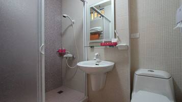 Une salle de bain avec une douche, un lavabo et des toilettes.