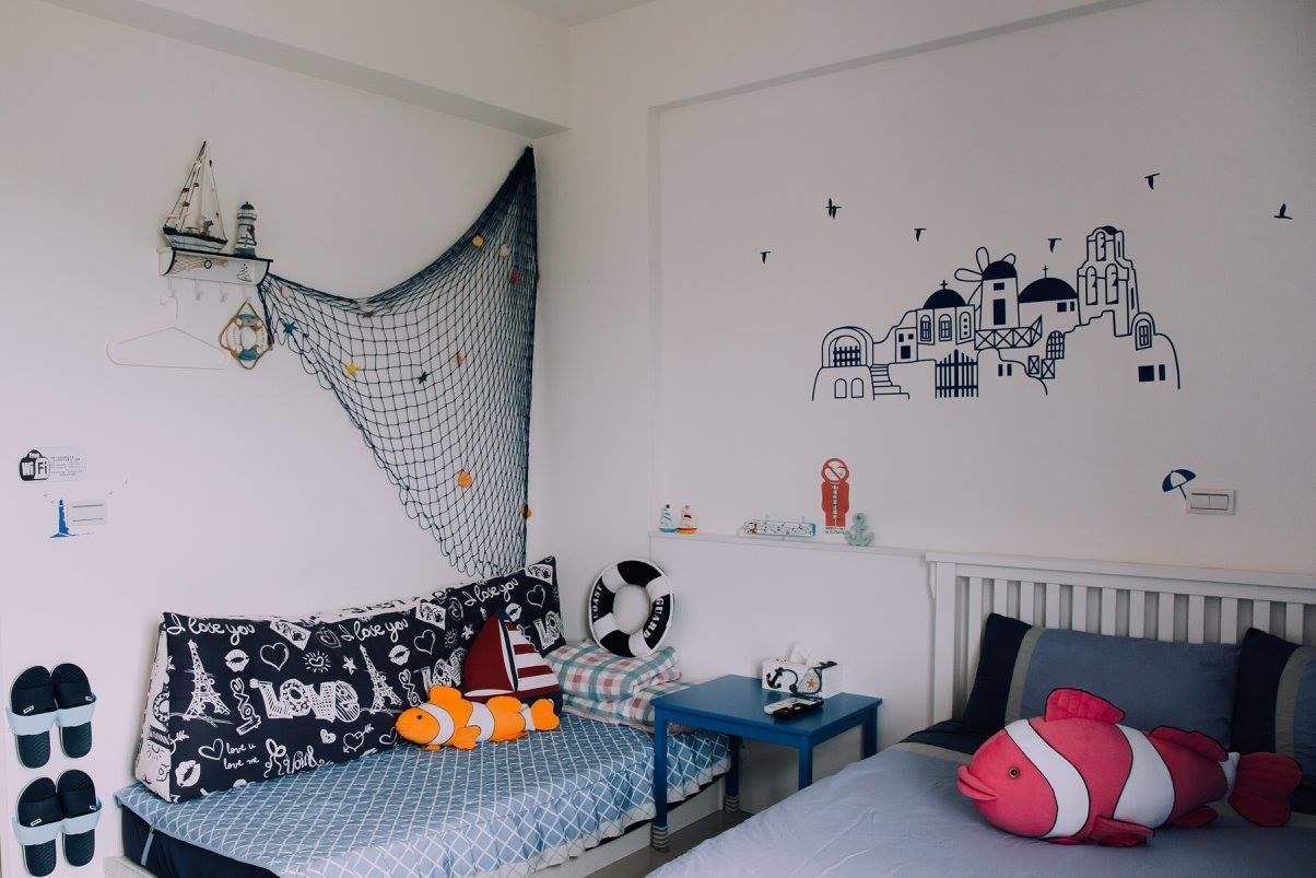 A bedroom with a bed, a hanging hammock, a wall mural, and a shelf with various items.