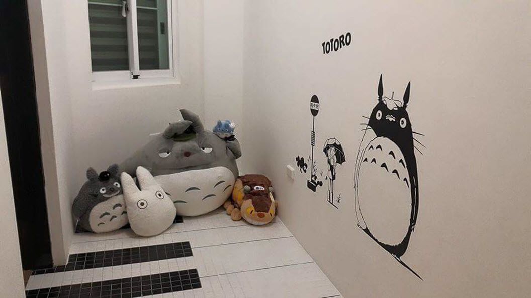 Ein Zimmer mit weißer Wand, die ein Totoro-Wandbild, ein Fenster und einen Fliesenboden zeigt.