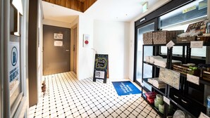 A hotel lobby with a check-in counter, a reception desk, and a tiled floor. - Hotel S-Presso North (Osaka)