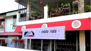 A hotel named Casa Mia with a signboard displaying contact information and a logo. - Casa Mia (Guwahati)