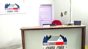 A reception desk with a sign reading "casa mia" and a logo depicting a house with mountains. - Casa Mia (Guwahati)
