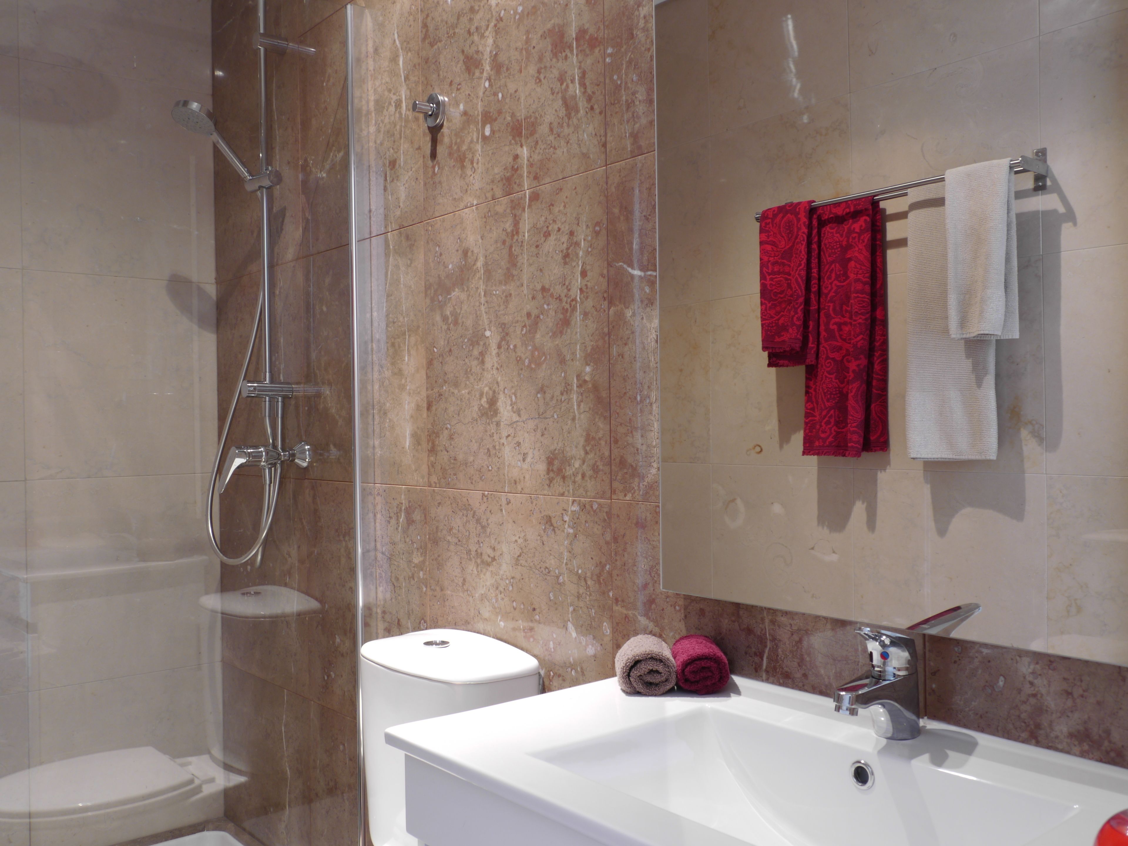 A bathroom with a shower, toilet, and sink.