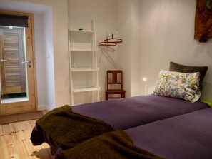 A bedroom with a bed, a chair, a shelf, and a door. - Cacilhas Guest Apartments (Almada)