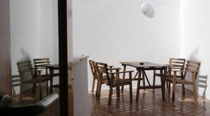 A room with a tiled floor, a white wall, and a wooden table with four chairs. - Cacilhas Guest Apartments (Almada)